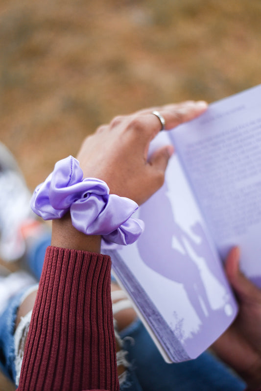 model reading book outdoor with lavender coloured aromatic loops fragrance scrunchie for relaxation and wellness